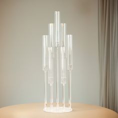 four tall clear vases sitting on top of a table