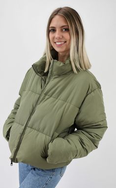 Warm and Fashionable. This cropped puffer jacket adds just the right style to any outfit while keeping you warm. The jacket has a front zipper and pockets to maximize fashion and ease with a back adjustment to cinch the waist for the most flattering fit. Wear this now for those chilly days or on gameday to add just the right color to your outfit. Pairs nicely with Color Fleece Crop. Color-Olive Green (also available in Stone, Blue, Teal, Cheddar Gold, Caramel, Cream, Black, Pale Lavander, Charcoal Blue, Pale Pink, Sky Blue, Hot Pink, Milk Chocolate, Orange, Green, and Lime Green) 80% Polyester 20% Nylon Back Adjustment, Green Puffer Jacket, Green Puffer, Cropped Puffer Jacket, Puffer Jacket, Pale Pink, Color Scheme, Cheddar, Front Zipper