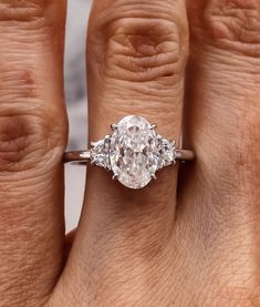 a woman's hand with a diamond ring on her left and an engagement band on her right