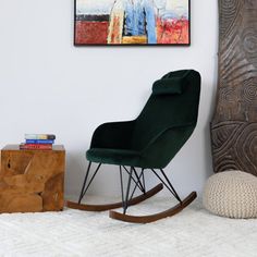 a green rocking chair sitting in front of a painting on the wall next to a white rug