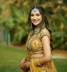 a beautiful woman in a yellow dress posing for the camera