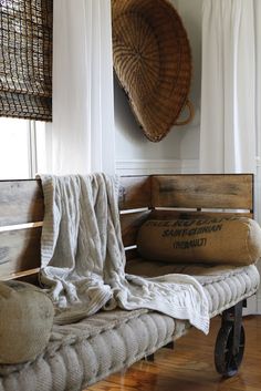 a couch with a blanket on top of it in front of a basket hanging from the wall