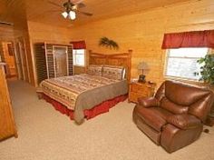 a bed room with a neatly made bed and a chair