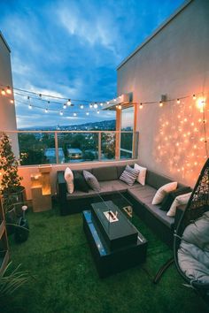 an outdoor living area with couches, tables and string lights on the roof top