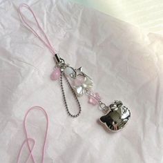 a pink lanyard with an animal charm attached to it's side on a white sheet