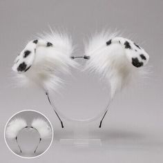 two white furry animal ears with black spots on the top and one is attached to a headband