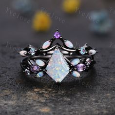 an opal and amethorate ring on top of a black stone surface