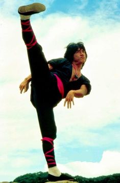 a man doing a handstand on top of a rock with his feet in the air