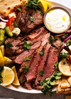 a plate with meat, vegetables and pita bread