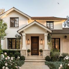 a white house with lots of windows and flowers