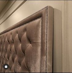 an upholstered headboard with studding on the sides and buttons at the bottom