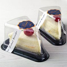 two pieces of cake sitting on top of each other in plastic containers with labels attached to them