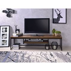 a living room with a large television on top of a wooden table in front of a gray wall