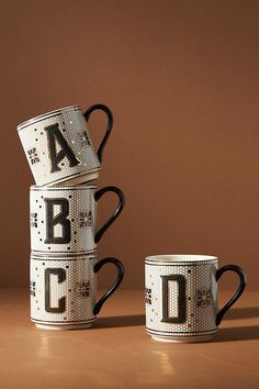 three coffee mugs stacked on top of each other with the letters abc and d