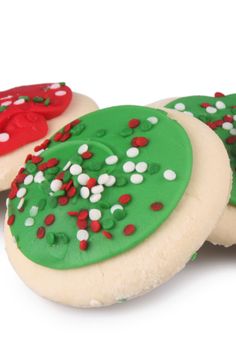 three decorated cookies with sprinkles and red, white, and green frosting