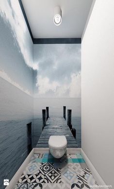 a toilet sitting on top of a tiled floor next to a wooden pier in the ocean