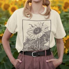 "Sunshine" Sunflower Graphic Tshirt This classic unisex jersey short sleeve tee fits like a well-loved favorite. Soft cotton and quality print make users fall in love with it over and over again. These t-shirts have-ribbed knit collars to bolster shaping. The shoulders have taping for better fit over time. Dual side seams hold the garment's shape for longer.  *FOR AN OVERSIZED LOOK SIZE UP 1-2 SIZES* MATERIALS: Printed on Gildan 18000 sweatshirts for a relaxed and casual fit. These sweatshirts are so soft and comfortable! .: 100% Airlume combed and ringspun cotton (fiber content may vary for different colors) .: Light fabric (4.2 oz/yd² (142 g/m .: Tear away label SIZING: Please refer to the sizing chart to find the perfect fit for your style. .: Retail fit .: Runs true to size DESIGN/PRIN Sunflower Graphic, Oversized Look, Casual Fit, Unisex Shorts, Casual Fits, Christmas List, Cotton Fiber, Aesthetic Clothes, Fall In Love