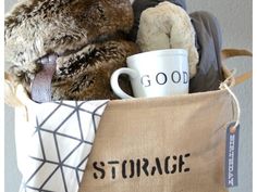 a teddy bear sitting in a storage bag next to a coffee mug and other items