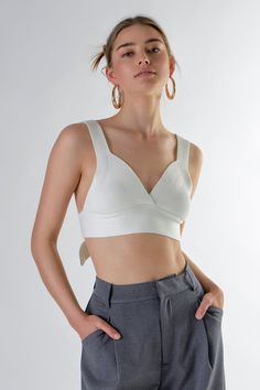 This bralette was made for flaunting. The Back Tie Elevated Knit Bralette offers just the right amount of coverage with a little extra something-something. The knit fabrication is stretchy and comfortable while the back tie detail gives this bralette a little extra flair. The thick straps provide support and the cropped length is perfect for showing off your favorite high-waisted bottoms. Knit fabrication Cropped length V-neckline Thick straps Back tie detail Hand wash cold Do not bleach Do not Fitted Cotton Halter Top With Built-in Bra, Stretch Halter Top With Built-in Bra And Strappy Back, Fitted Seamless Halter Top With Tie-side Bottom, Cotton Halter Top With Built-in Bra, Cotton Sleeveless Halter Top With Built-in Bra, Knit Bralette, White Bralette, Something Something, Mini Dress Shop