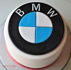 a white and black cake with a blue bmw logo on it