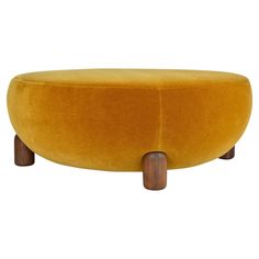 a yellow ottoman with wooden legs and an upholstered foot rest on the bottom