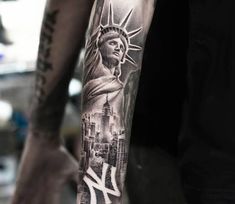 a man's arm with a statue of liberty tattoo on it