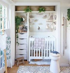 a baby's room with white furniture and plants