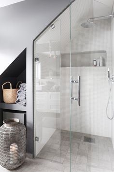 a bathroom with a glass shower door next to a toilet