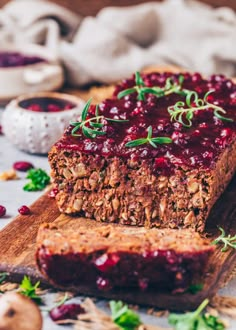 two slices of meatloaf with cranberry sauce on a wooden cutting board