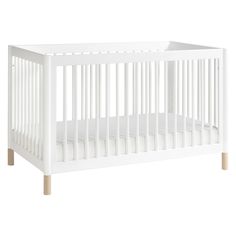 a white crib with green legs and no mattress in the bottom half, against a white background