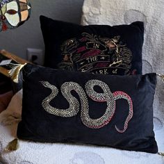 two black pillows sitting on top of a white chair