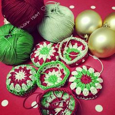 crocheted christmas ornaments and balls of yarn on a red table with white polka dots