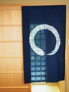 a blue flag hanging from the side of a wooden wall next to a shelf filled with books