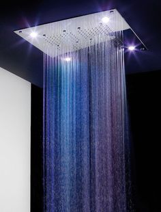 a shower head with blue and purple water flowing from it's side to the other side