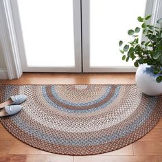 a pair of shoes sitting on top of a rug next to a potted plant