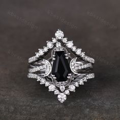 a black and white diamond ring on a dark surface with diamonds around the band, set in 18k white gold