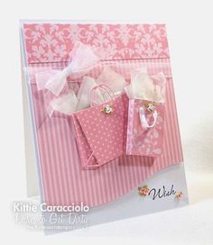 a pink and white card with two bags on it