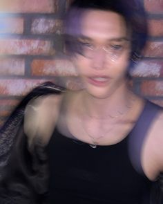 a blurry photo of a woman in front of a brick wall