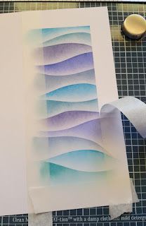 the paper is being cut and placed on top of the cutting mat to make an abstract painting