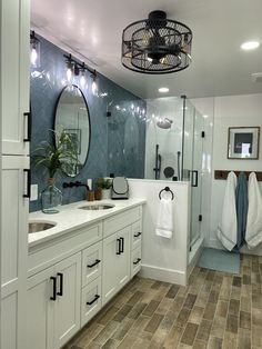 a bathroom with two sinks, a shower and a large mirror on the wall above it