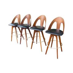 four wooden chairs with black leather seats and backrests, all in the same color