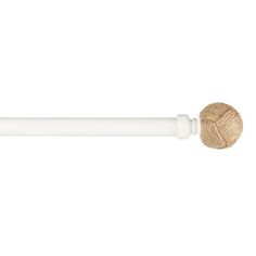 a ball of yarn sitting on top of a white pole with a wooden stick sticking out of it