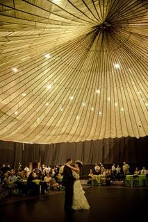 a bride and groom sharing their first dance in front of an audience at a wedding