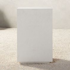 a white box sitting on top of a carpeted floor in front of a wall