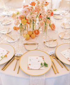 the table is set with place settings and flowers