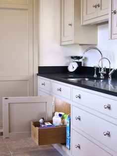 a kitchen with white cabinets and black counter tops is shown in this image, there are two sinks under the cabinet