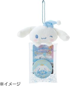 a white stuffed animal in a package on a string with a tag hanging from it's side