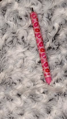 a pink pen sitting on top of a white fur covered floor next to a red object