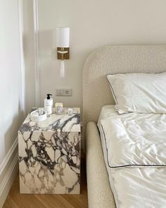 a marble side table next to a bed