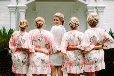 a group of women standing next to each other wearing matching robes and hair buns